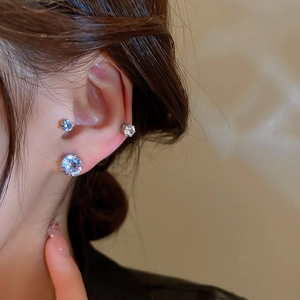 Close-up of magnetic zircon ear clips with silver base shown on a model side profile