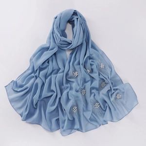 Close-up of blue chiffon hijab scarf with delicate floral beadwork and pearl accents