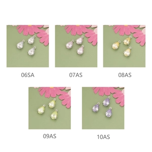 Macro detail of tear-drop zircon pendants in five pastel colors with metal ring hooks