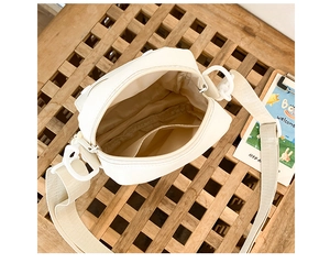 Interior detail of the beige canvas bear bag showing the inner pocket and strap