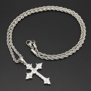 Détail du pendentif croix en argent serti de zircons sur une chaîne torsadée