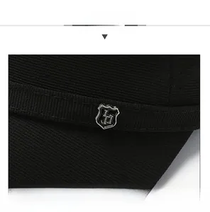 Detailed close-up of a silver metal shield badge on a black textured knit baseball cap