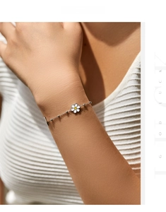 Close-up of s925 silver daisy bracelet with white enamel petals on model wrist