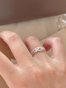 Detail view of 925 sterling silver double-layer ring with fish charm on finger