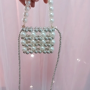 Detail of beaded mini bag showing white pearls and silver beads weave with metal chain