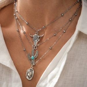 Detail of silver western multi-layer necklace featuring bull skull and turquoise cactus
