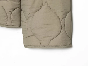 Close-up of khaki leopard print quilted jacket cuff with detailed stitching finish