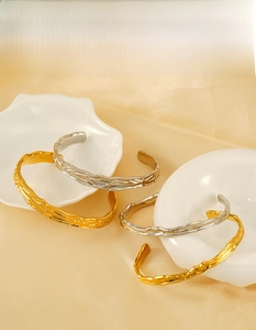 Dettaglio della trama irregolare della corteccia sui bracciali in oro 18K e acciaio