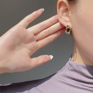 Close-up of elegant gold irregular geometric S925 silver stud earrings on model