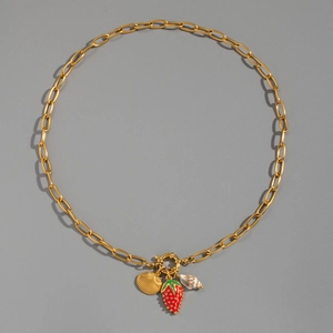 Dettaglio della collana in oro 18K con ciondoli a conchiglia, fragola e lumaca