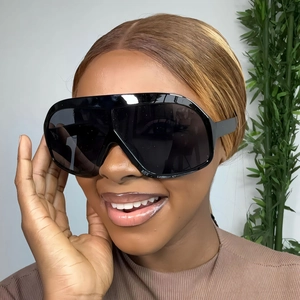 Close-up of black oversized square sunglasses worn by a model for a chic retro fashion look