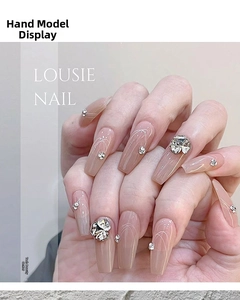 Vue macro d'ongles trapèze nude avec des strass argentés 3D et des lignes blanches fines