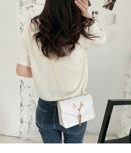 White PU leather crossbody bag featuring gold deer head ornament and tassel detail