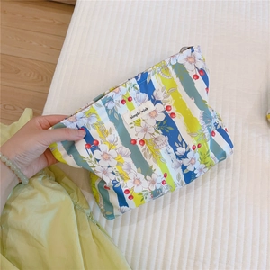 Detail of floral printed cotton cosmetic bag with simple wish label and zip closure