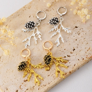 Close-up of vintage pine cone and branch earrings in antique silver and gold finish