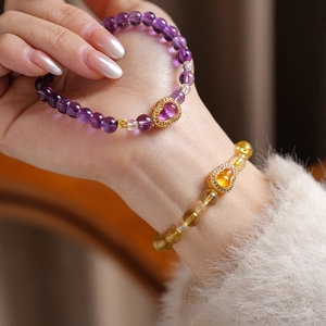 Detailed shot of citrine and amethyst bead bracelets with gold gourd pendants for women