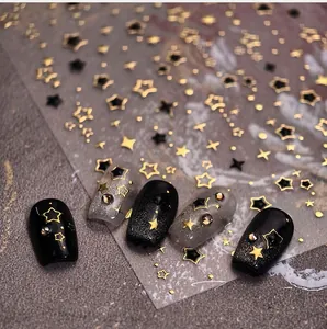 Detail of gold star nail stickers with metallic foil stars on black and silver nails