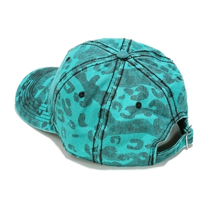 Détail de la boucle métallique et texture denim léopard sur la casquette de baseball