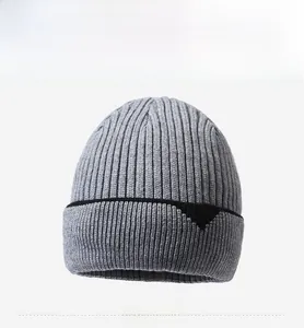 Detail view of grey knit beanie featuring ribbed texture and black stripe accent