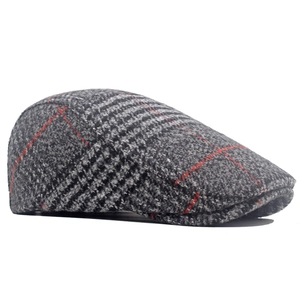 Detailstruktur aus grauem und rotem Woll-Tweed-Karo auf einer britischen Schiebermütze