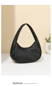 Detail shot of black woven texture on a hobo shoulder bag over a minimalist background