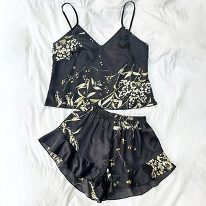 Two-piece black floral satin pajama set with camisole top and ruffled shorts for women