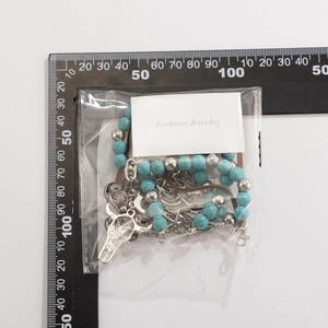 Detail view of bohemian turquoise beaded necklace with silver bull head pendant on white card