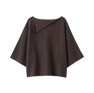 Détail d'un haut en tricot marron foncé avec col asymétrique et texture côtelée douce