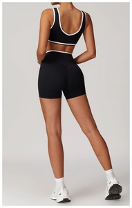 Detail of cross-back sports bra and high-waisted shorts with white contrast trim