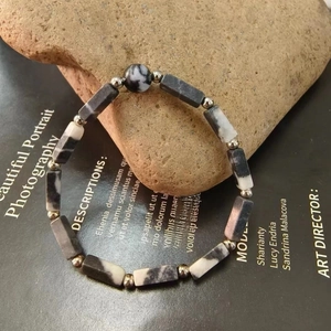 Detail of natural zebra stone beaded bracelet with rectangular facets and metal spacers