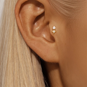 Macro view of gold s925 silver stud earring with white zircon and star-shaped detail