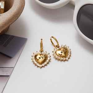 Detail of 18K gold stainless steel heart earrings with LOVE engraving and white crystals