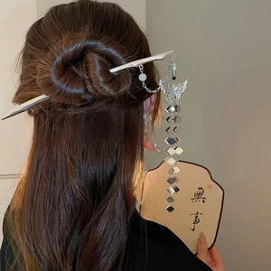 Silver butterfly hair stick with tassel pendant shown on a model in traditional style