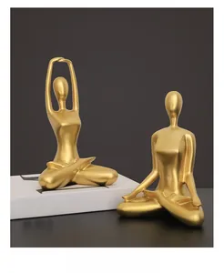 Detail of two abstract yoga statues in matte gold finish for modern home decor