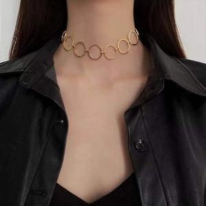 Detailed close-up of a high-polish gold choker necklace with linked circular geometric rings