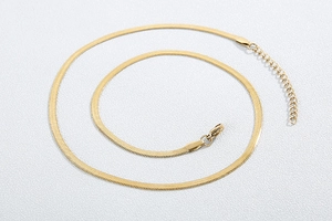 Détail du collier à chaîne serpent plate dorée avec fermoir mousqueton et rallonge