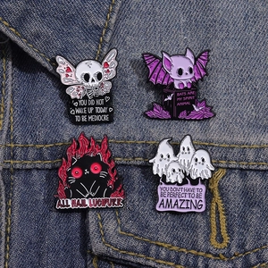 Cartoon enamel pins set featuring skull, bat, black cat and ghost on blue denim fabric