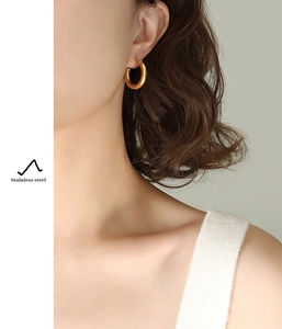 Detail of minimalist 18K gold plated stainless steel hoop earrings on female model