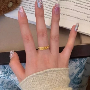 24k gold-plated open ring with hollow clover pattern shown in a lifestyle setting