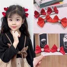 Detail of red satin bow hair clip with heart rhinestone decoration for girls