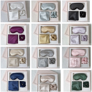 Detailed grid of 12 silk sleep gift sets with eye masks and scrunchies in various colors
