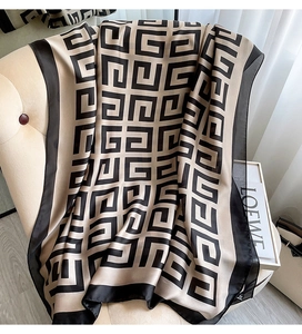 Detail of elegant houndstooth silk scarf draped over a chair in a stylish setting