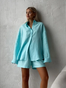 Detailed texture of light blue linen shirt and shorts set with loose fit on a model