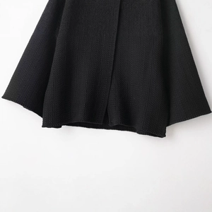 Fashionable black waffle knit jacket with button structure and textured A-line hem