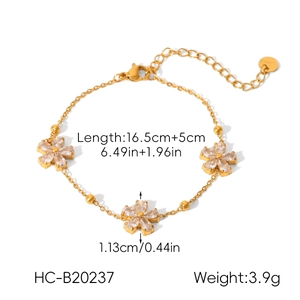 Detail of gold chain bracelet featuring zircon flower charms and lobster clasp closure