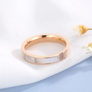 Detail of 18K rose gold plated ring with white shell inlay and three small diamonds