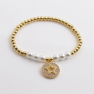 Detail of gold beaded bracelet with pearls and a sparkling zircon star charm