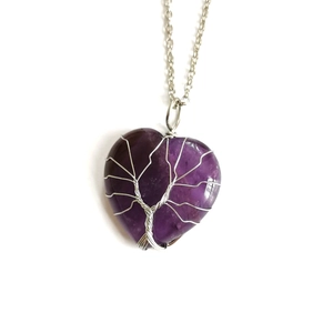 Detail of silver wire-wrapped Tree of Life on heart-shaped purple crystal pendant