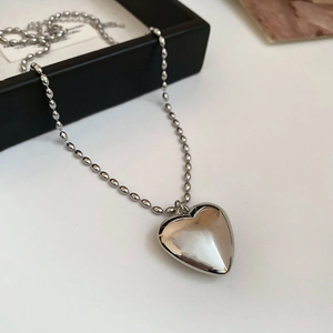 Elegant silver woven bag pendant necklace with a textured heart and bead chain