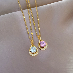 Macro detail of teardrop pendants with white and pink stones on wavy titanium steel chains
